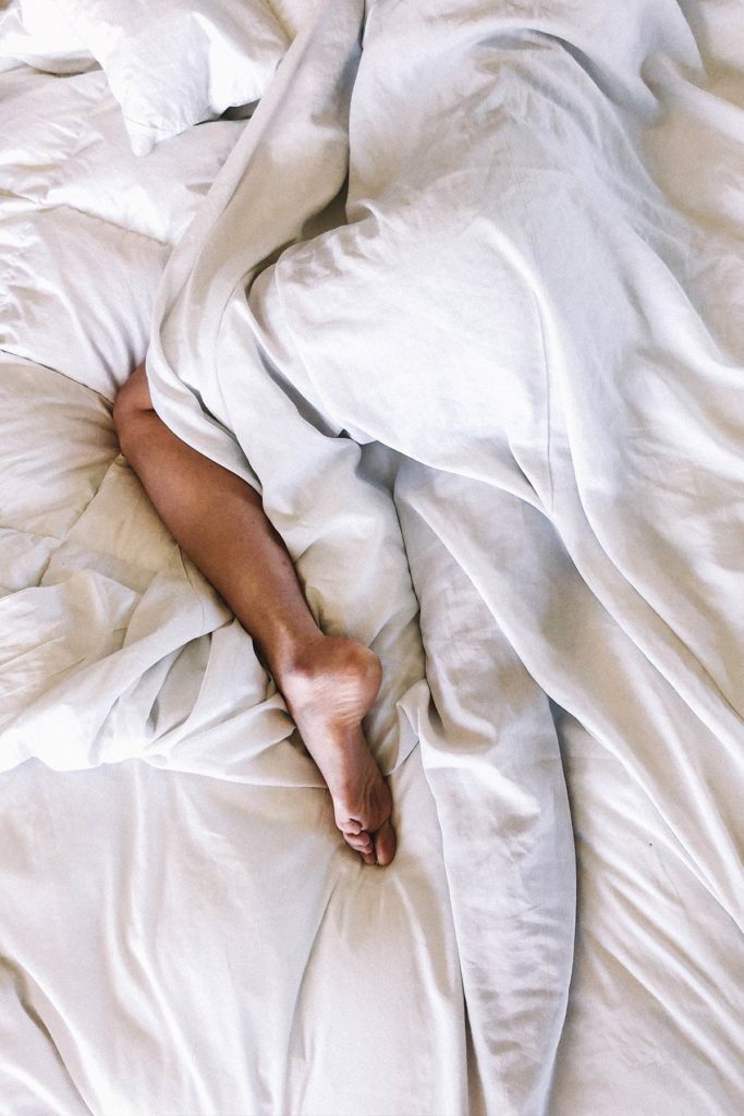 Bed with white sheets and a person sleeping