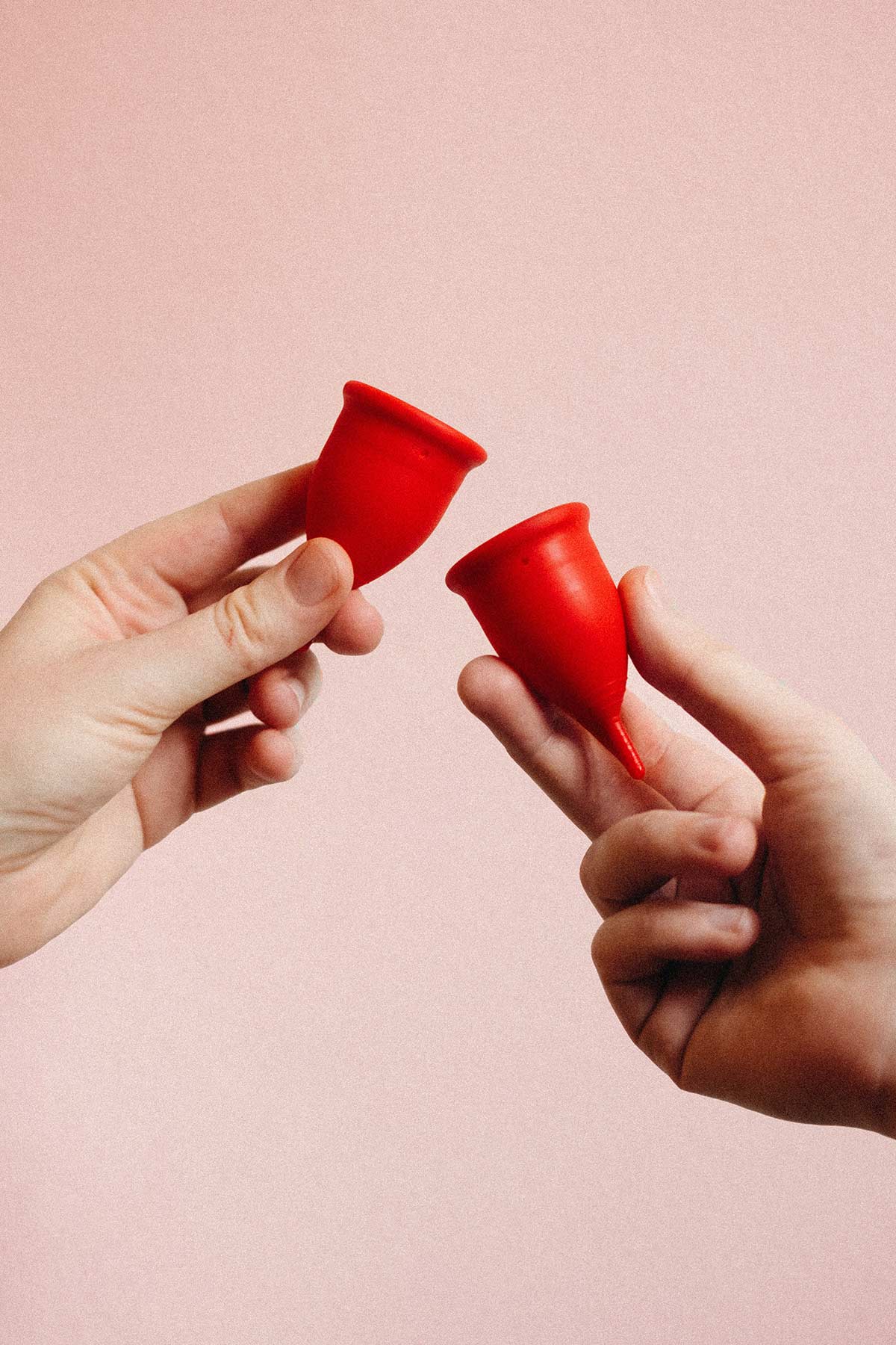 red menstrual cups with hands