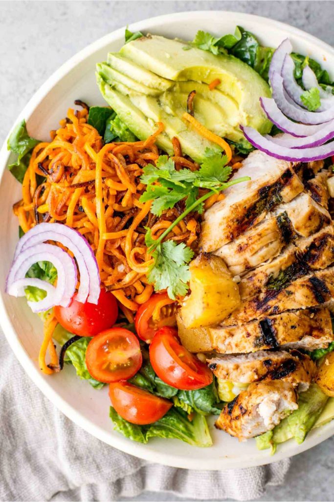 spring salad with grilled chicken, sweet potatoes, avocado, grilled pineapple and tomato