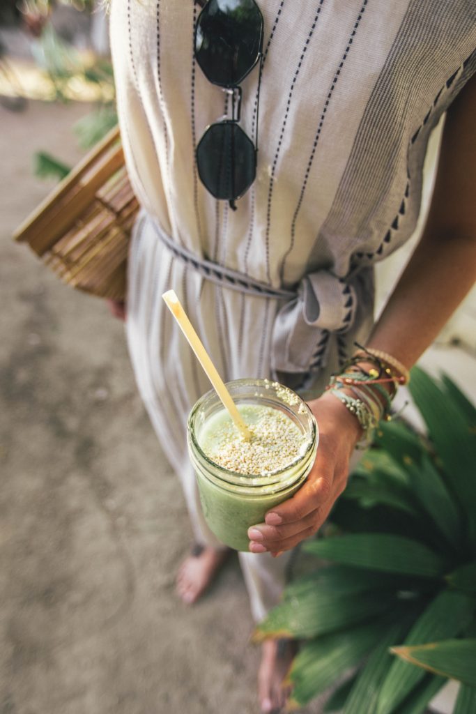 make health simple woman holding green smoothie with straw
