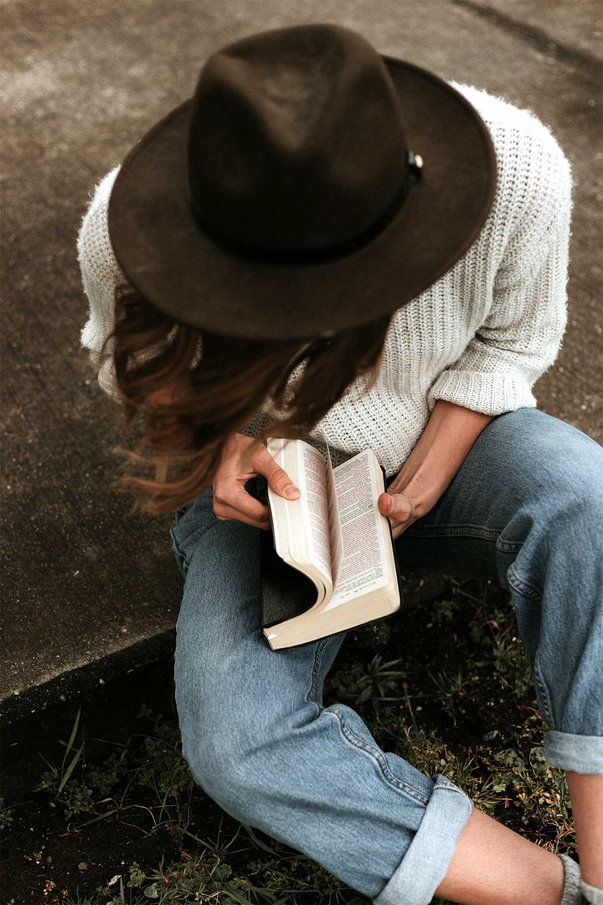 Girl with hat reading the bible